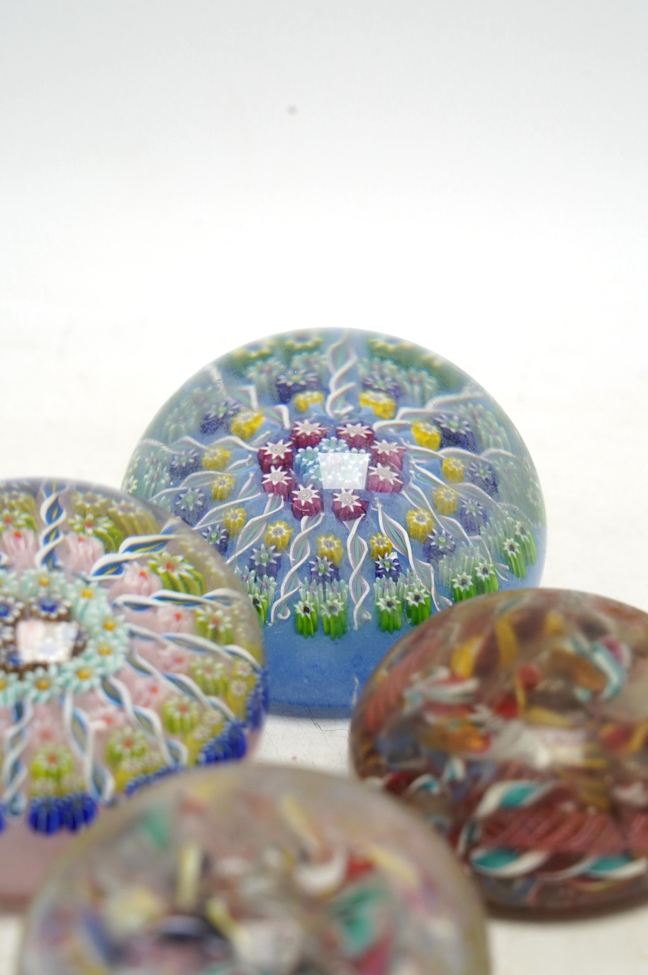Two Perthshire millefiori glass paperweights and two scrambled glass paperweights, largest 7cm wide. Condition - fair